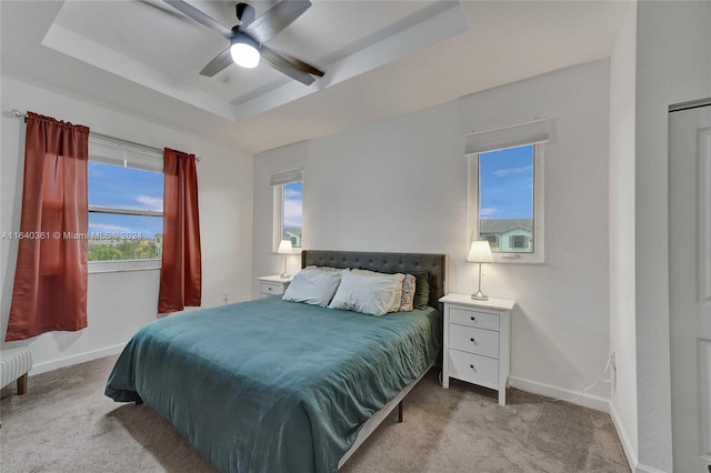 bedroom featuring multiple windows, light colored carpet, and ceiling fan