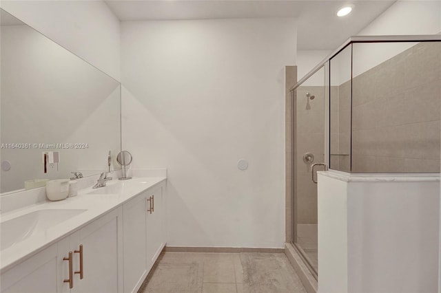 bathroom with a shower with door, vanity, and tile patterned floors