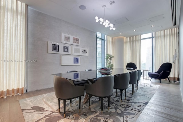 dining room featuring an inviting chandelier, light wood-type flooring, and floor to ceiling windows