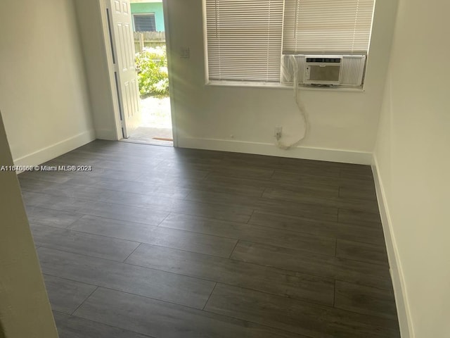 unfurnished room with baseboards, visible vents, cooling unit, and dark wood-style floors