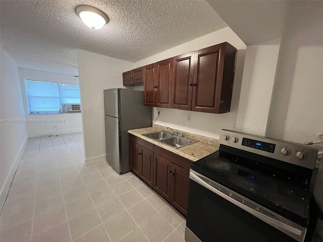 kitchen featuring a textured ceiling, a sink, stainless steel appliances, light countertops, and dark brown cabinets