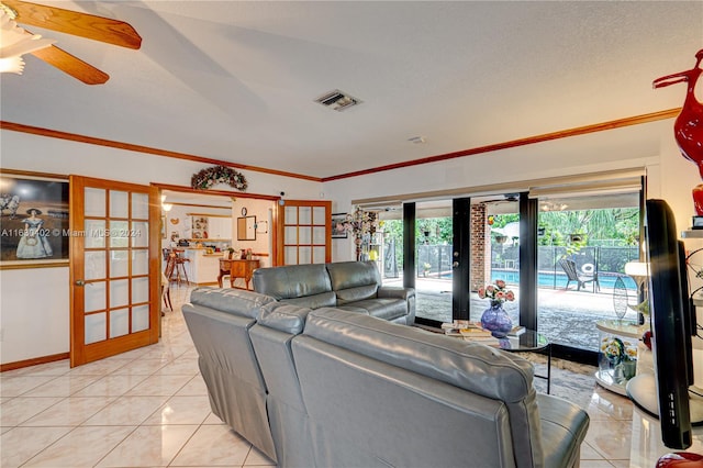 living room with a textured ceiling, ceiling fan, french doors, and light tile patterned flooring