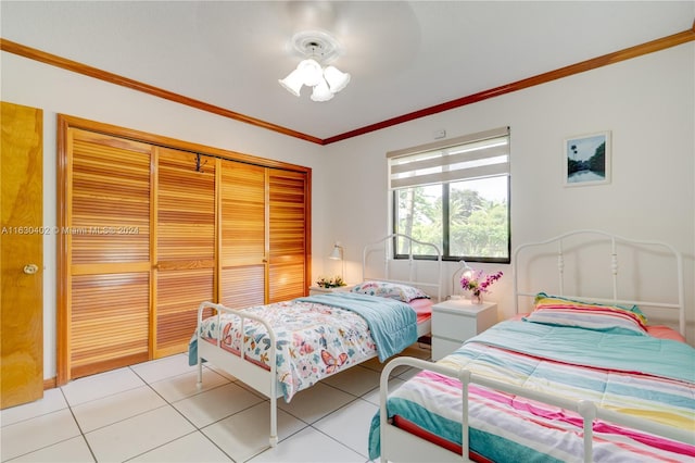 bedroom with a closet, crown molding, and light tile patterned flooring