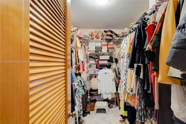 walk in closet with light tile patterned floors