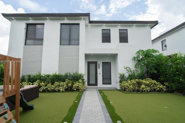 rear view of house featuring a lawn