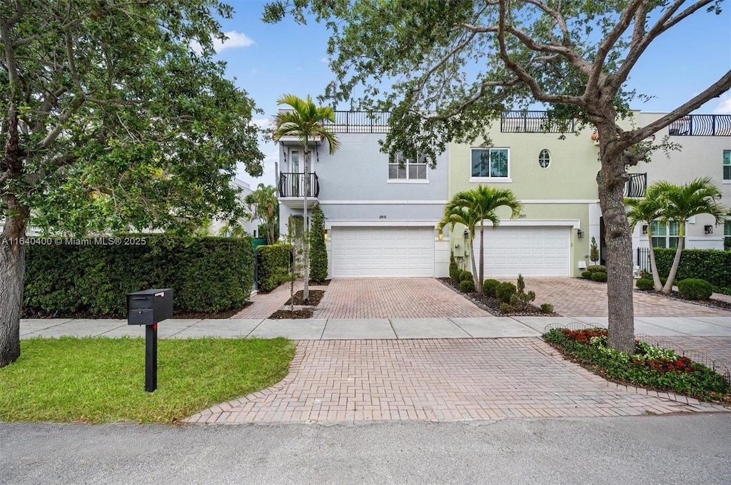 2515 NE 18th St, Fort Lauderdale, FL 33305 - view of front of property with decorative driveway, an attached garage, stucco siding, and a balcony