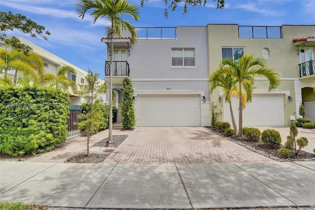 view of front of property featuring a balcony and a garage