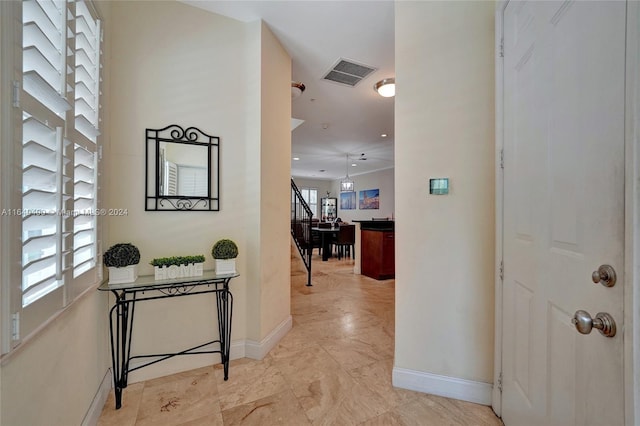 corridor featuring baseboards, stairs, and visible vents