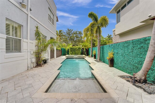 view of swimming pool with pool water feature and a patio area