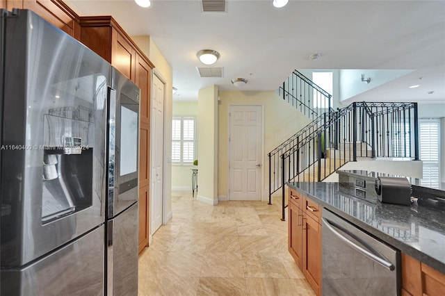 kitchen featuring light tile patterned floors, appliances with stainless steel finishes, and dark stone counters