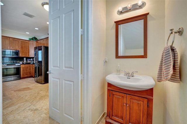 bathroom featuring tasteful backsplash, vanity, and tile patterned flooring