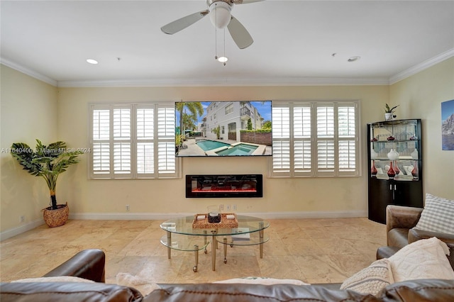 living area with a glass covered fireplace, crown molding, and baseboards