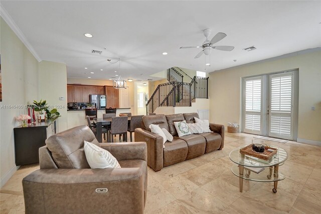 tiled living room featuring ornamental molding and ceiling fan with notable chandelier