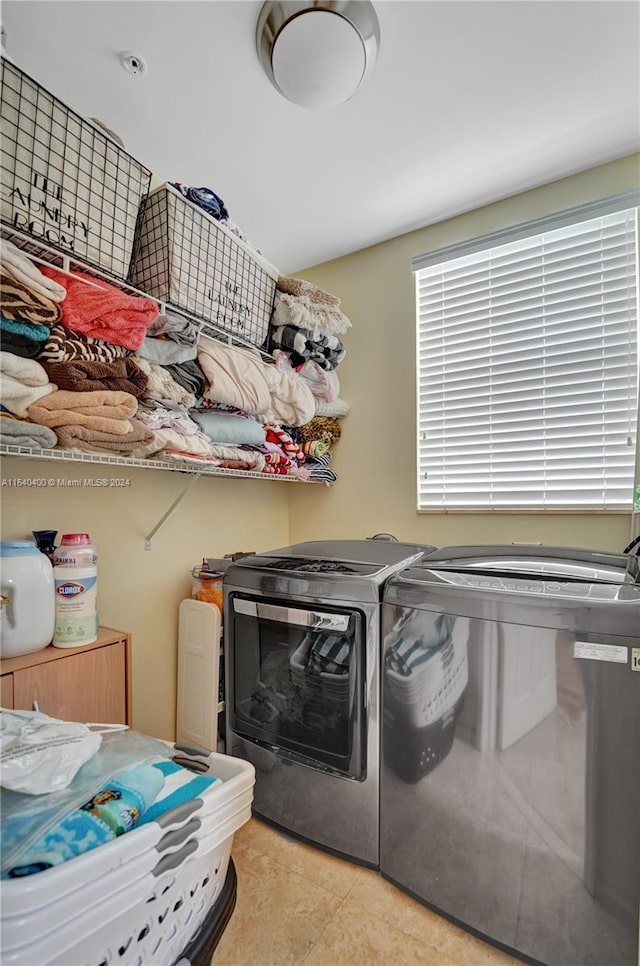 laundry area with washer and dryer, laundry area, and light tile patterned flooring