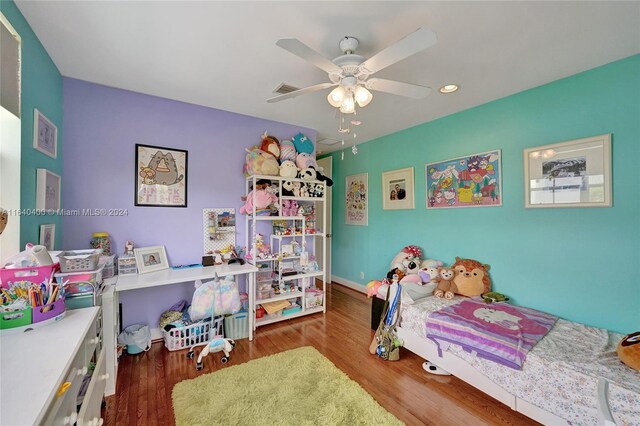 bedroom with dark hardwood / wood-style flooring and ceiling fan