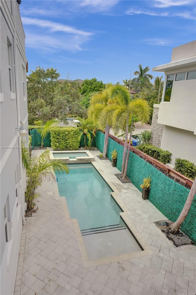 view of swimming pool featuring an in ground hot tub and a patio