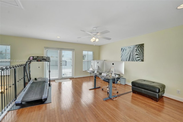 exercise room with ceiling fan, light wood-style flooring, and baseboards