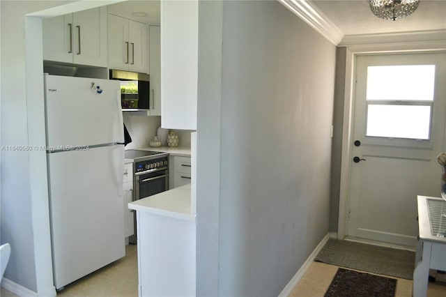 kitchen featuring light tile patterned flooring, plenty of natural light, ornamental molding, and white refrigerator