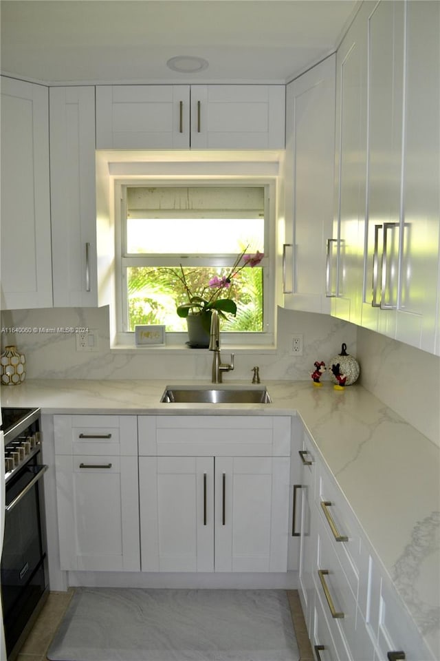 kitchen featuring sink, white cabinetry, electric range, and decorative backsplash