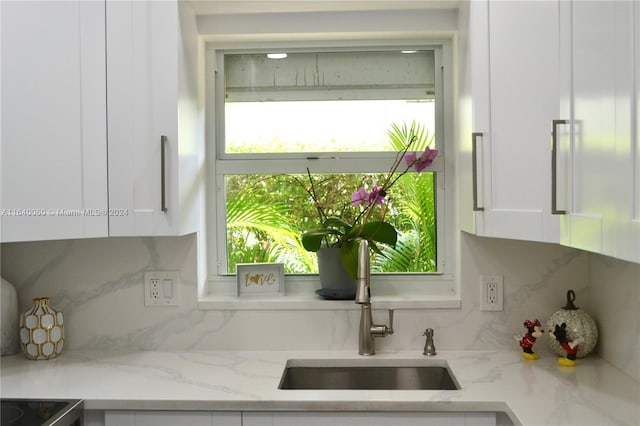 kitchen with tasteful backsplash, white cabinets, and plenty of natural light