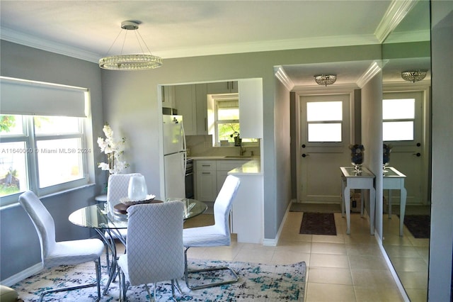 tiled dining area with a notable chandelier, ornamental molding, and sink