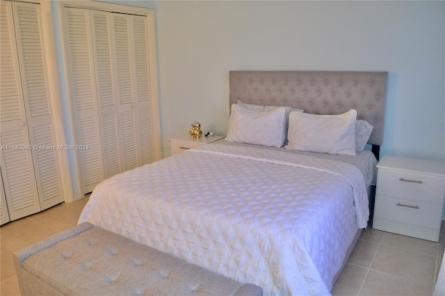 bedroom with two closets and light tile patterned floors