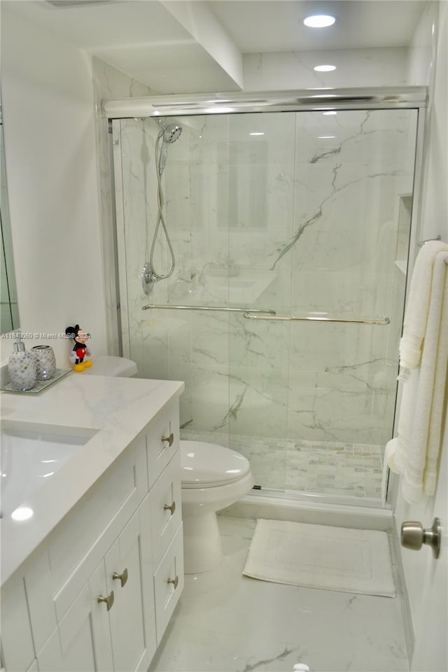 bathroom featuring vanity, toilet, tile patterned flooring, and a shower with shower door