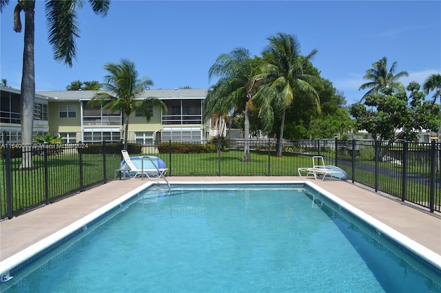 view of pool with a sunroom and a lawn