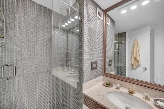 bathroom with shower / bath combination with glass door and vanity