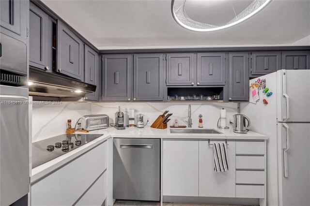 kitchen featuring white refrigerator, gray cabinets, black electric stovetop, sink, and stainless steel dishwasher