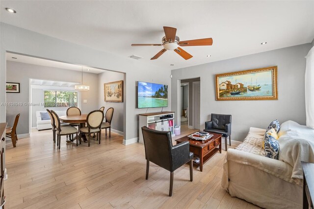 living room with ceiling fan and light hardwood / wood-style flooring