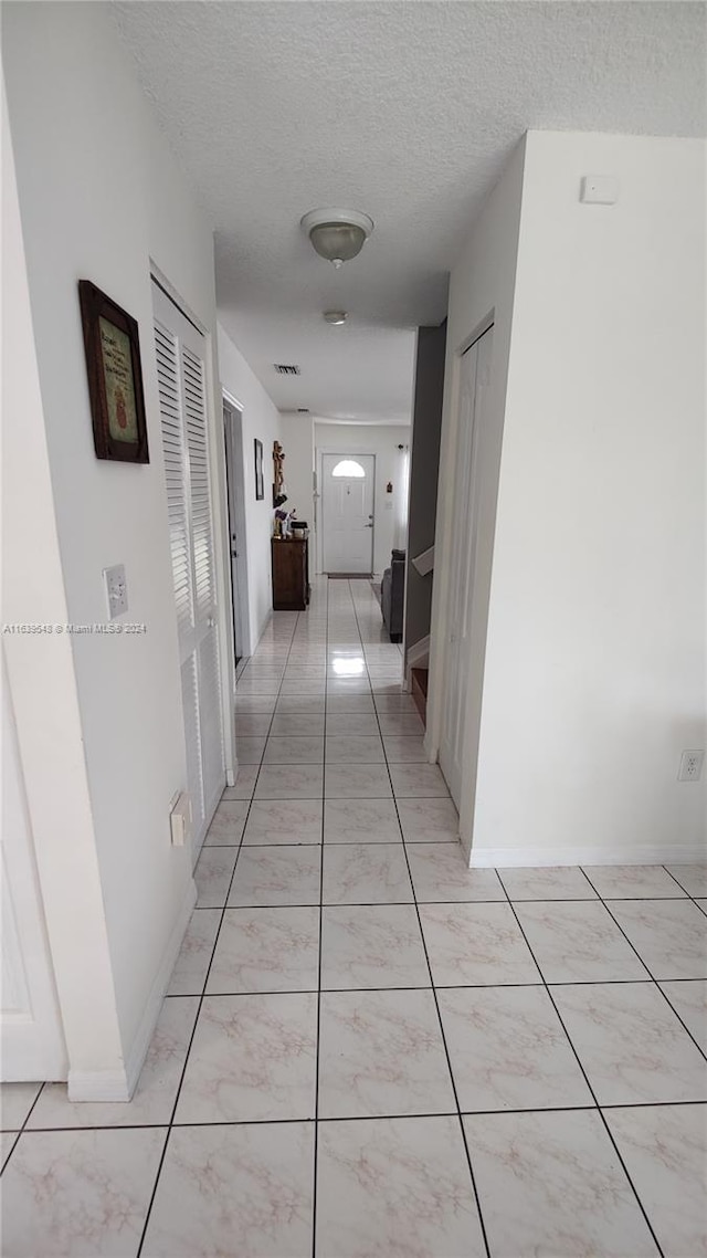 hall with a textured ceiling