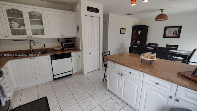 kitchen featuring white cabinetry, decorative backsplash, dishwasher, and sink