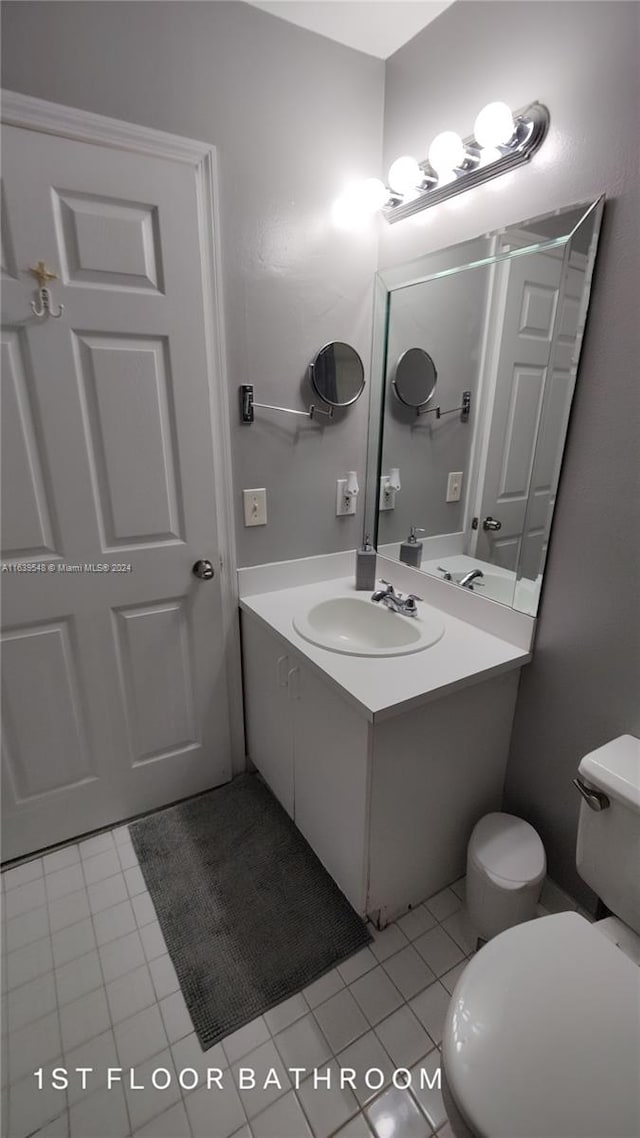 bathroom with vanity, toilet, and tile patterned floors