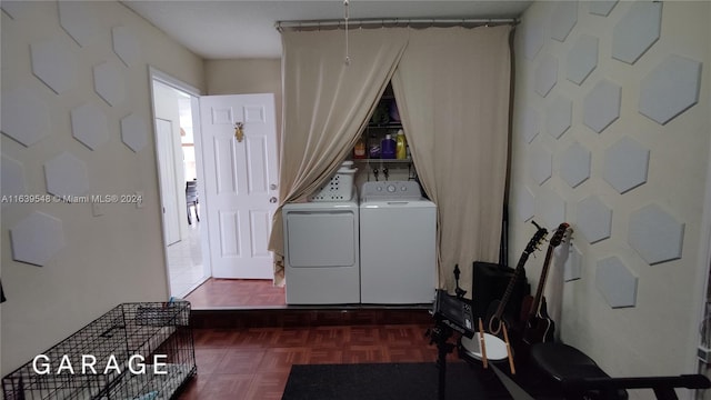 clothes washing area with dark parquet flooring and separate washer and dryer