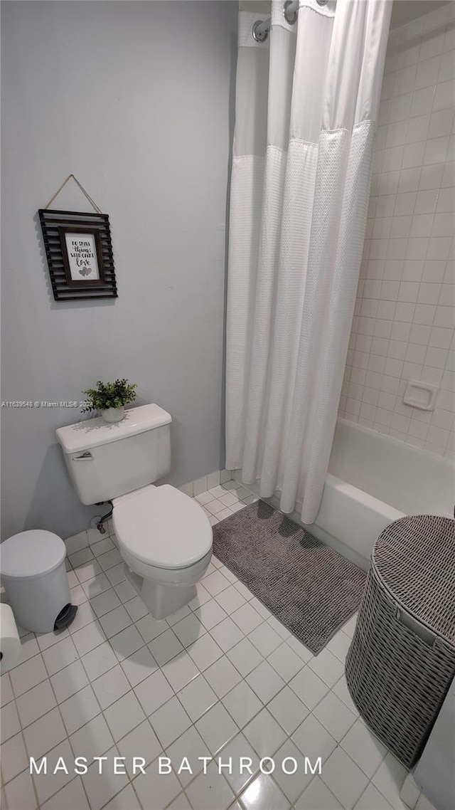 bathroom featuring toilet, shower / bathtub combination with curtain, and tile patterned flooring