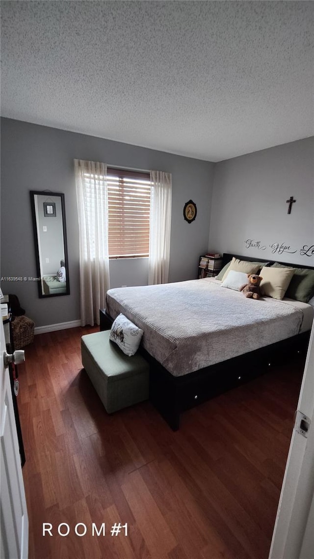 bedroom featuring a textured ceiling and dark hardwood / wood-style flooring