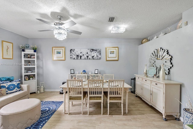 dining room featuring a textured ceiling, ceiling fan, and light wood-type flooring