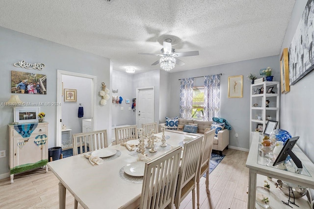 dining area with light wood-type flooring, ceiling fan, and a textured ceiling