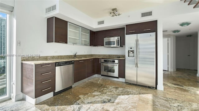 kitchen with dark brown cabinetry, sink, and stainless steel appliances