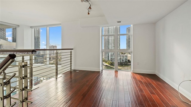 unfurnished room featuring wood-type flooring and floor to ceiling windows