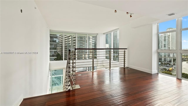 spare room with a wall of windows and wood-type flooring