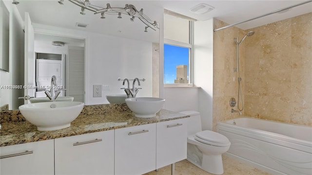 full bathroom with tiled shower / bath combo, vanity, and toilet