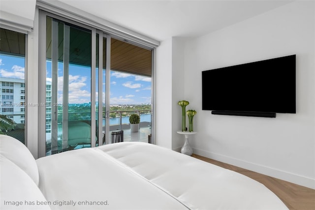 bedroom with expansive windows, parquet floors, and access to exterior