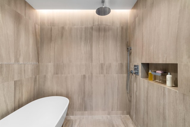 bathroom featuring tile walls and shower with separate bathtub