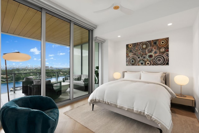 bedroom with ceiling fan, floor to ceiling windows, access to exterior, and light parquet floors