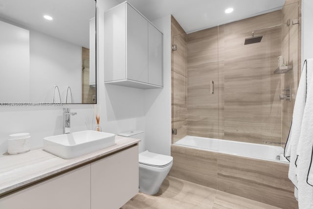 full bathroom featuring vanity, toilet, and combined bath / shower with glass door