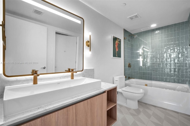 full bathroom featuring toilet, tiled shower / bath combo, vanity, and tile patterned floors