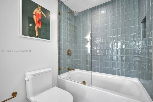 bathroom with toilet and tiled shower / bath