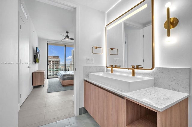 bathroom featuring a wall of windows, vanity, tile patterned flooring, and ceiling fan